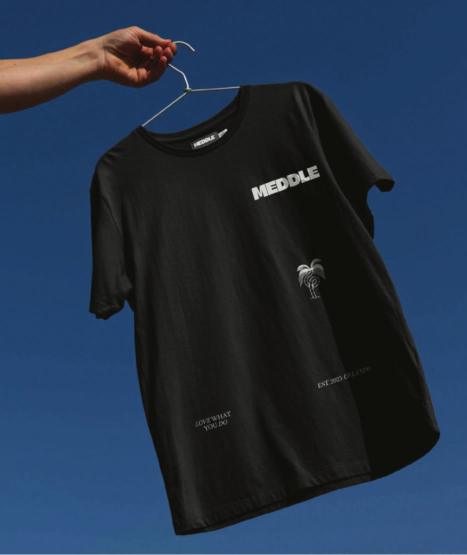 Black Meddle shirt held against a blue sky